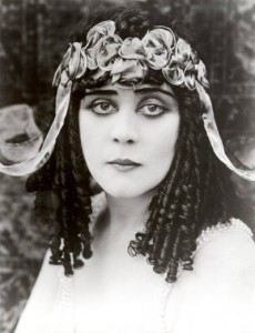 Theda Bara (born  Theodosia Goodman, 18851955), Jewish silent screen actress famous for her femme fatale roles. Note the corkscrew curls mentioned earlier by Keats (curled Jewesses). The  classic Hollywood femme fatale, Wikipedia tells us, was often foreign, of an indeterminate Eastern European or Asian ancestry. THEDA BARA, by the way, is an anagram for ARAB DEATH. Go figure.